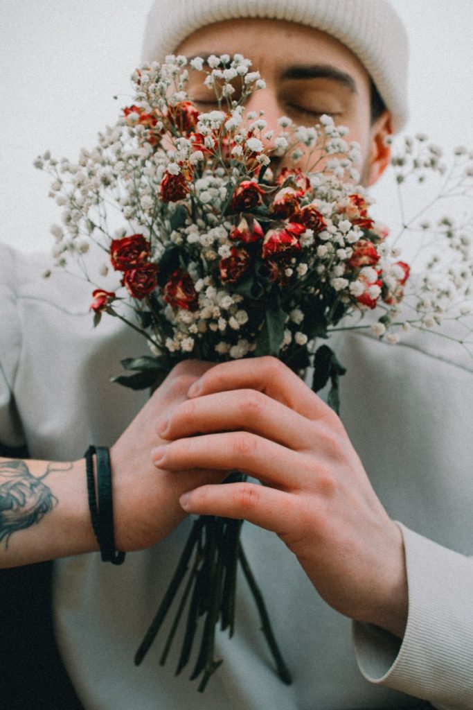 a man holding a bunch of flowers in his hands